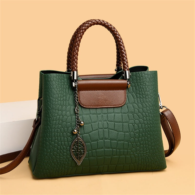 Borsa a spalla da donna con texture coccodrillo e dettagli di manici intrecciati, design strutturato e raffinato.