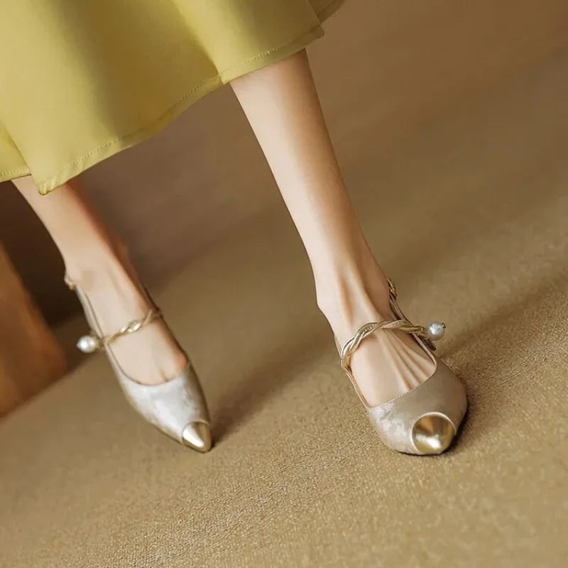 Raffinati tacchi a gattino slingback, scarpe a punta con perla e accenti oro. Stile moda donna.