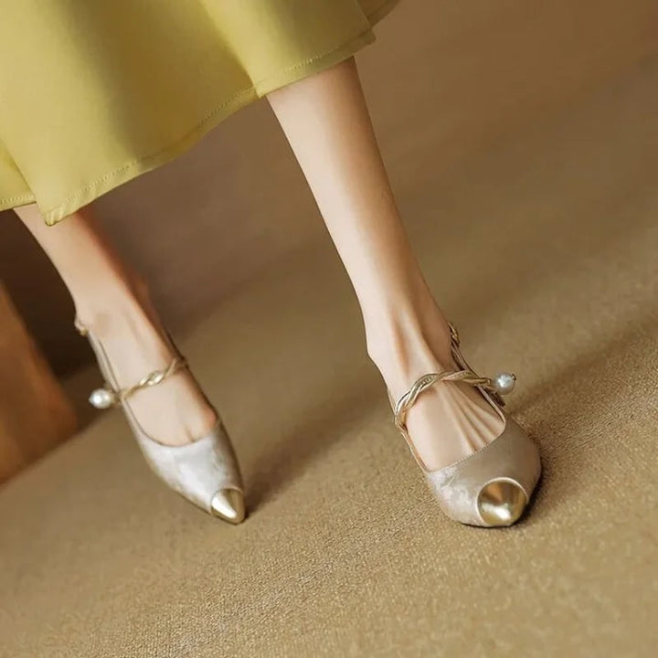 Raffinati tacchi a gattino slingback, scarpe a punta con perla e accenti oro. Stile moda donna.