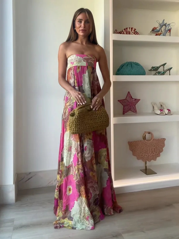 Dettaglio stampa floreale vivace su abito lungo donna con bustier, colori pastello.