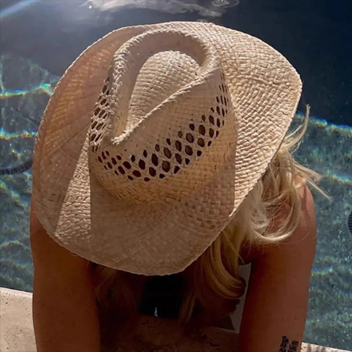 Elegante cappello in paglia beige con tesa larga da donna, accessorio moda estivo per spiaggia.