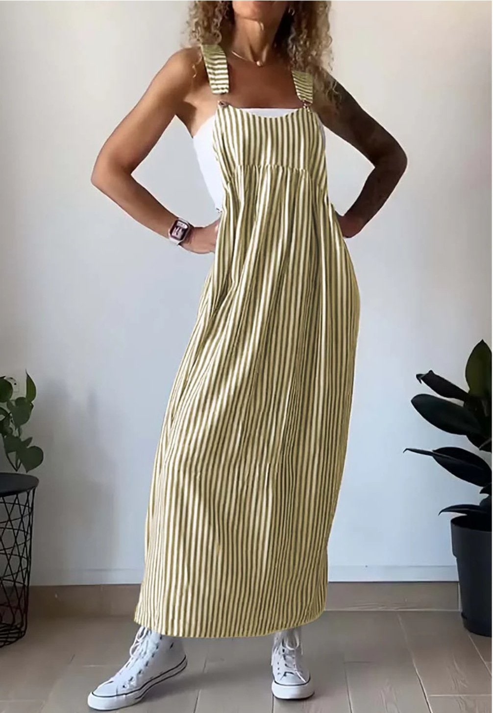 Donna con abito maxi pinafore a righe casual, perfetto per il giorno. Stile estivo versatile e comodo.