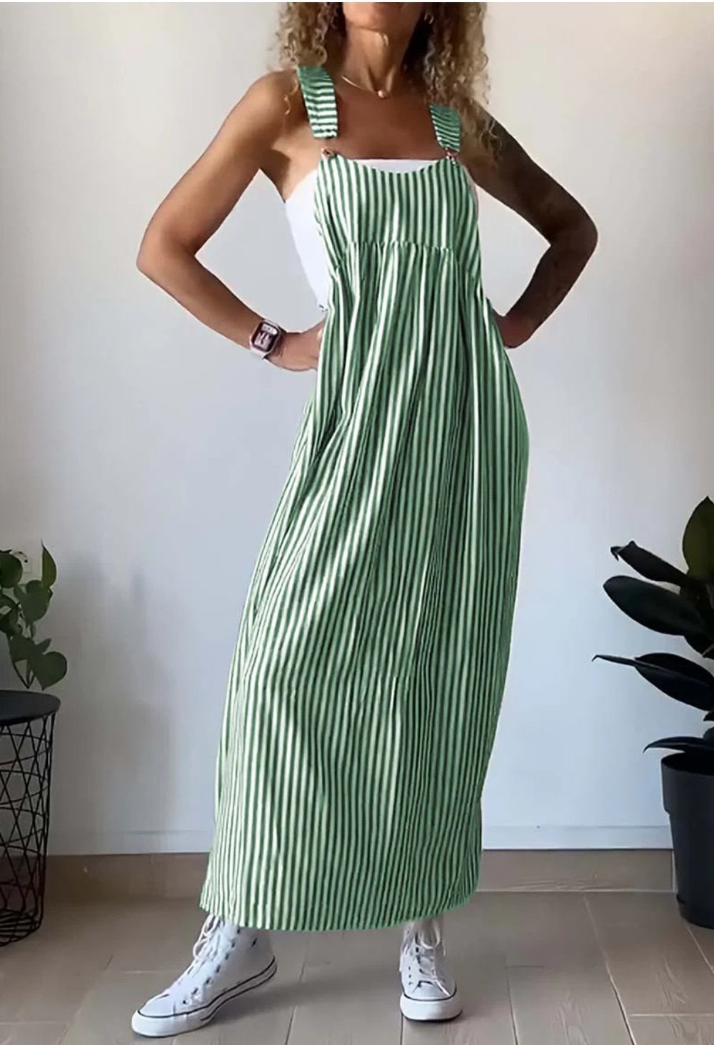 Abito maxi pinafore a righe donna, indossato con accessori eleganti per una serata estiva chic.