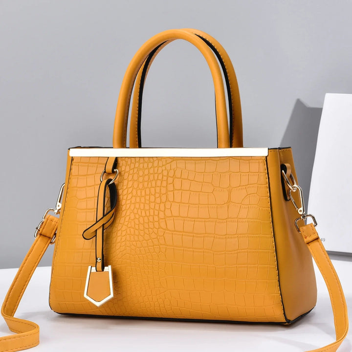 Borsa da donna in pelle coccodrillo, design strutturato con tracolla rimovibile e dettagli oro.