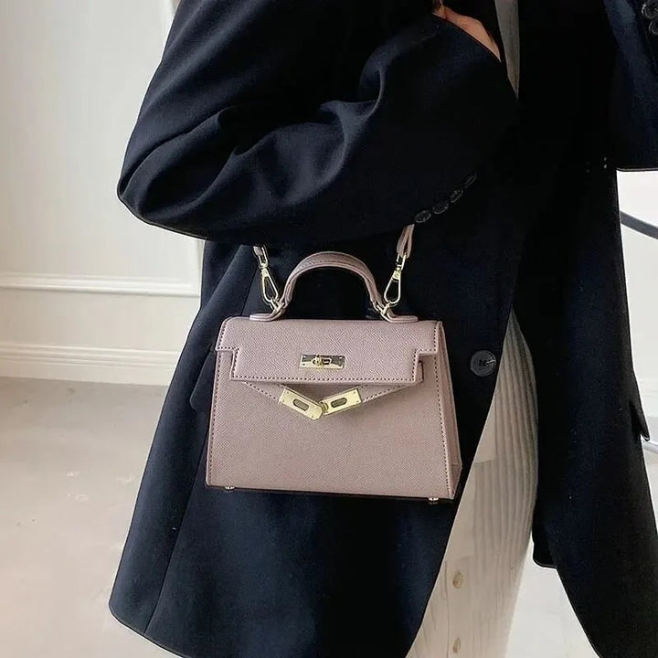 Borsa elegante da donna strutturata, con manico e tracolla. Chiusura dorata per un look chic da sera o lavoro.