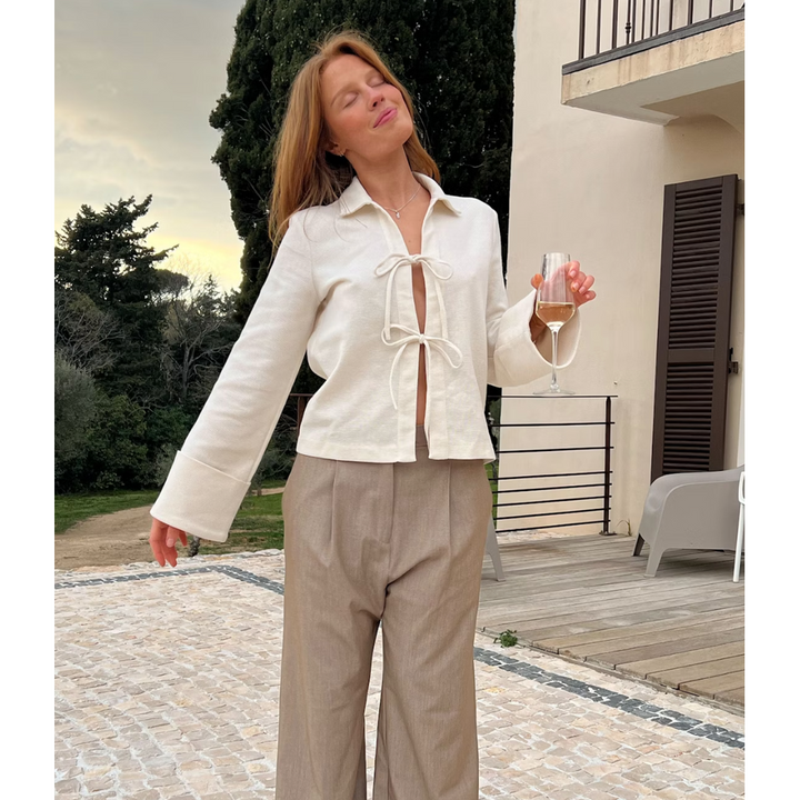 Top elegante primavera estate, blusa donna bianco crema con fiocco e maniche lunghe con polsini ampi.