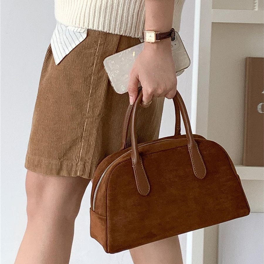 Elegante borsa a mano strutturata da donna con raffinata silhouette a cupola e pratica chiusura a zip.