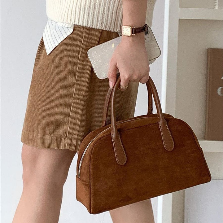 Elegante borsa a mano strutturata da donna con raffinata silhouette a cupola e pratica chiusura a zip.