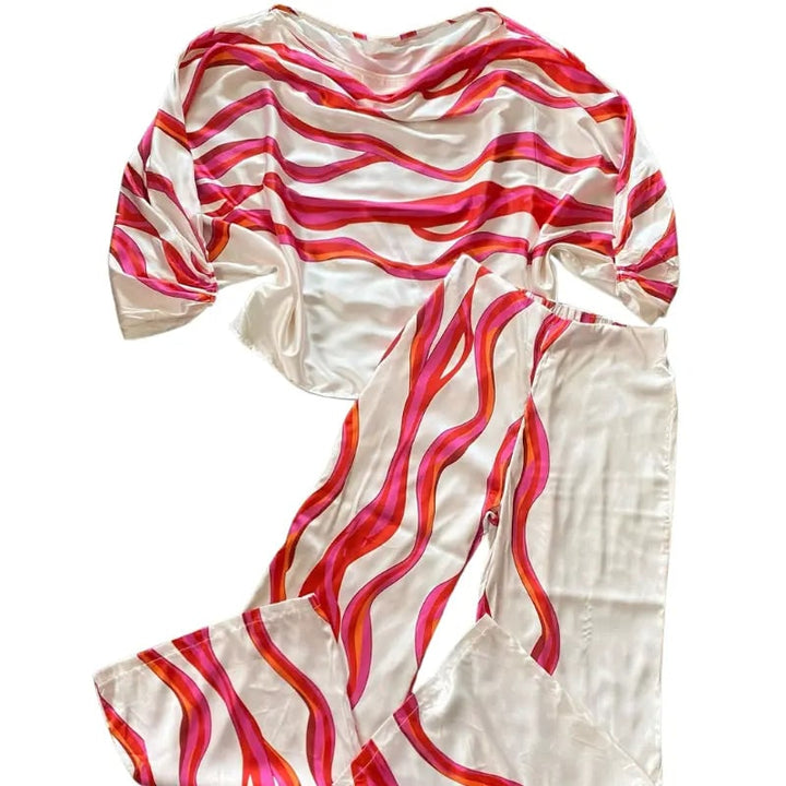 Top spalle scoperte e pantaloni larghi. Completo donna due pezzi elegante per un look estivo chic.