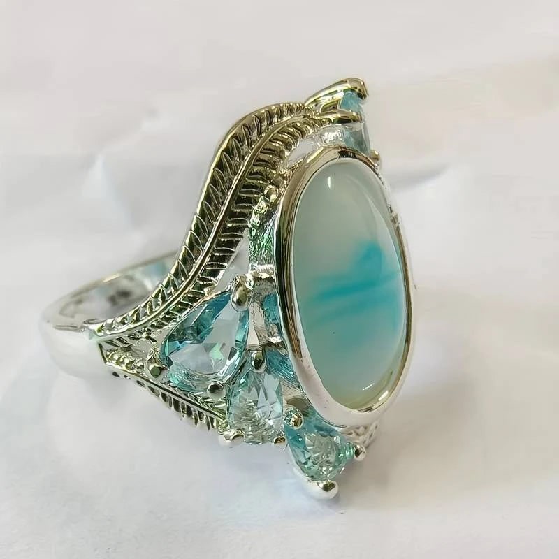 Anello da cocktail vintage donna elegante, con grande opale blu ovale e montatura placcata argento.
