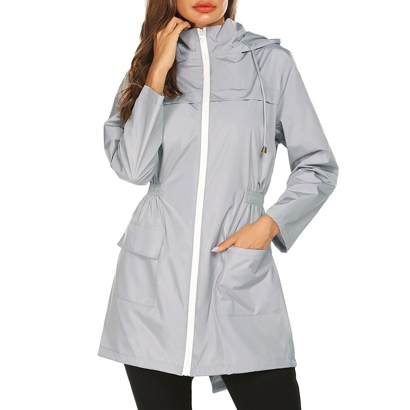 Elegante impermeabile donna con cappuccio e vita aderente, un capo antipioggia di moda per l'esterno.