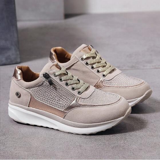 Sneakers donna grigie con zeppa, impreziosite da strass e cerniera laterale. Stile elegante e moderno.