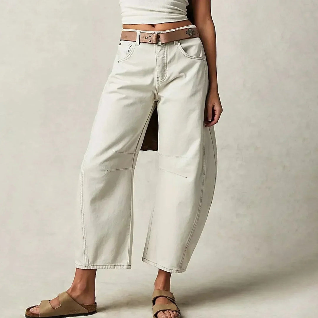 Jeans donna a gamba larga barrel, pinces al ginocchio, cuciture curve. Pantaloni moda femminile, stile moderno.
