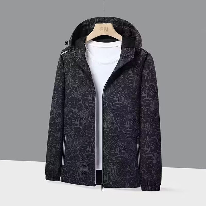 Giacca a vento da donna, leggera, con cappuccio e stampa foglie. Perfetta per running, trekking e casual.