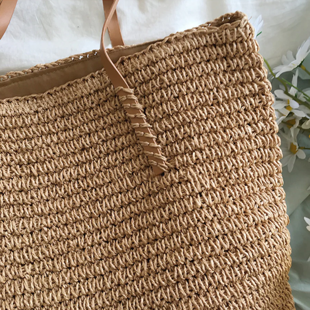 Borsa in paglia intrecciata con manici in ecopelle, stile tote donna, perfetta per un look estivo e disinvolto.