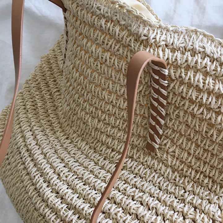 Borsa shopping donna in paglia intrecciata, leggera e spaziosa, con tracolle robuste in ecopelle per uso quotidiano.