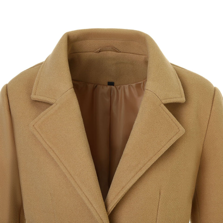 Donna indossa cappotto avvolgente elegante con revers e cintura. Ideale per un look raffinato in autunno.