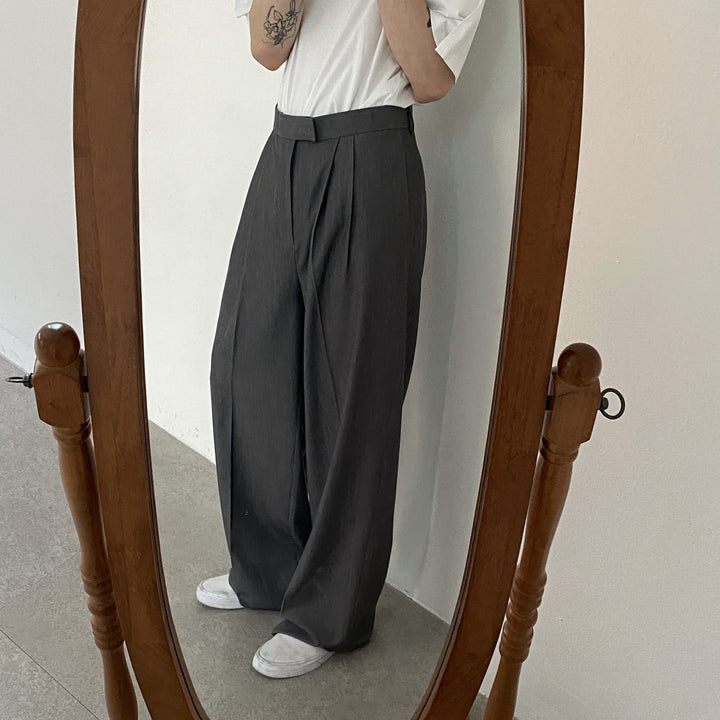 Modello di pantaloni uomo a gamba larga e pince, vestibilità rilassata per un outfit strutturato ed elegante.